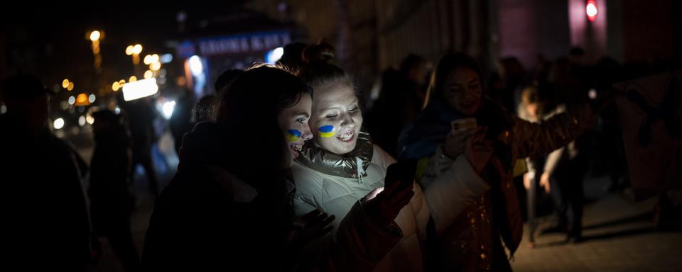 Deux ukrainiennes célèbrent la reprise de Kherson par l'Ukraine. [AP Photo/Keystone - Bernat Armangue]