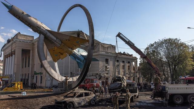 Des militaires ukrainiens déblaient les restes calcinés de véhicules à Vinnytsia, dans le centre du pays, après une frappe russe qui a fait au moins 23 morts. [Keystone - EPA/ROMAN PILIPEY]