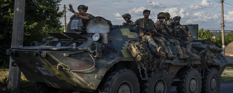 Des soldats ukrainiens sur un véhicule blindé de transport de troupes. [Keystone/AP Photo - Nariman El-Mofty]