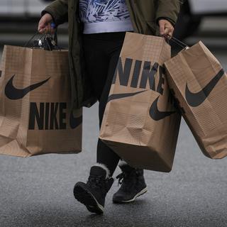 Une personne porte des sacs de la marque Nike. [The Canadian Press via AP/Keystone - Darryl Dyck]