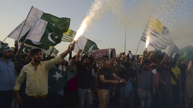 A Karachi (Pakistan), mercredi 27 février 2019, une foule en liesse célèbre les deux avions militaires indiens abattus par les forces pakistanaises dans la région contestée du Cachemire. Le pilote aurait été capturé, augmentant les tensions entre ces deux puissances nucléaires. [AP Photo/Keystone - Muhammad Rizwan]