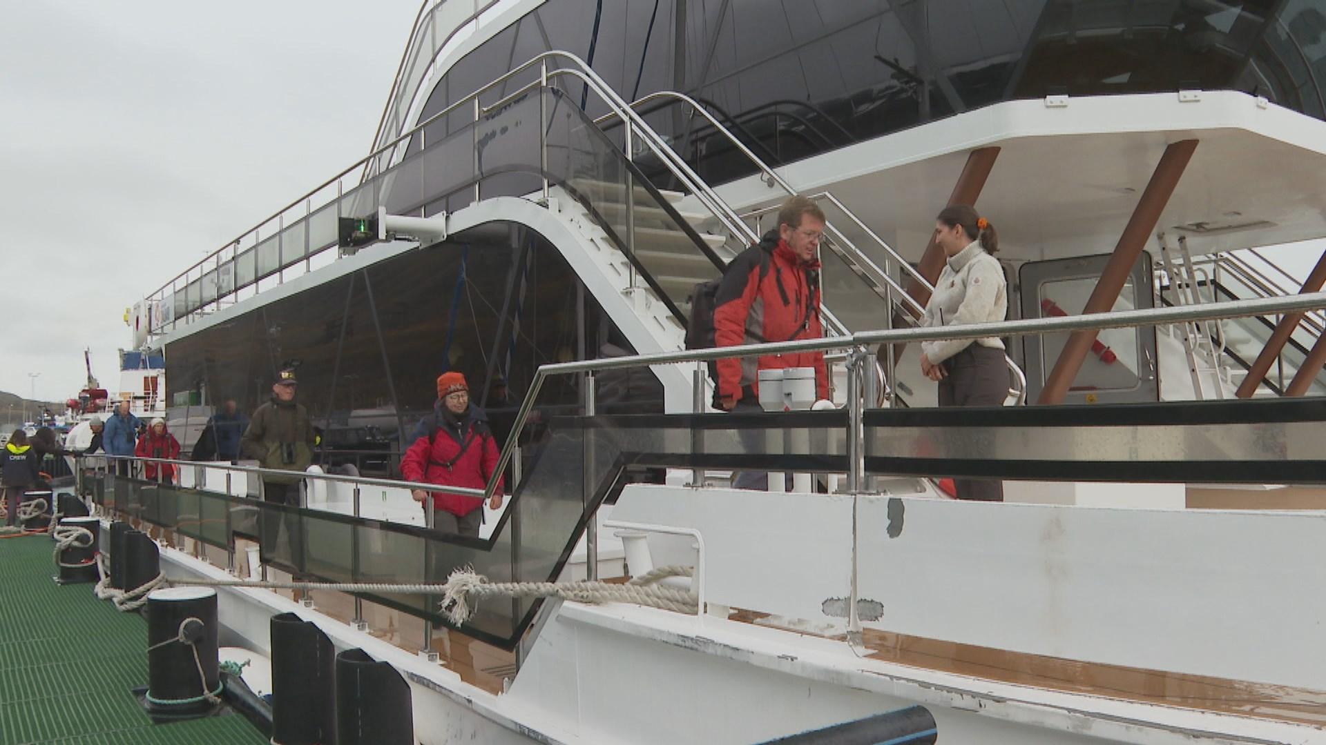 Des touristes grimpent à bord du catamaran hybride Kvitbjørn. [RTS - Flore Dussey/Yvan Illi]
