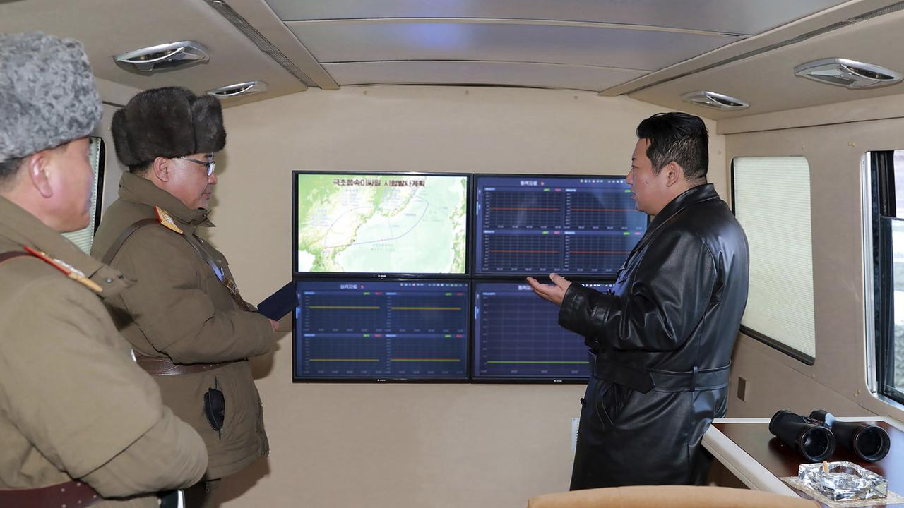 Le dirigeant nord-coréen Kim Jong Un, ici à droite, a supervisé le tir du missile hypersonique entouré d'hommes en uniforme militaire. [Korean Central News Agency/Korea News Service]