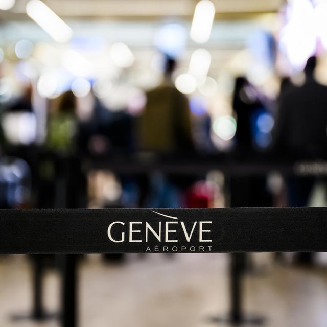 Des voyageurs avec des bagages à l'aéroport de Genève. [Keystone - Jean-Christophe Bott]
