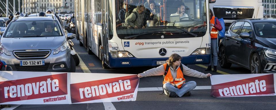 Les militants de "Renovate Switzerland" ont bloqué le pont du Mont-Blanc à Genève pour éxiger que le Conseil fédéral agisse en matière de rénovation énergétique des bâtiments. [Keystone - Martial Trezzini]