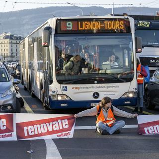 Les militants de "Renovate Switzerland" ont bloqué le pont du Mont-Blanc à Genève pour éxiger que le Conseil fédéral agisse en matière de rénovation énergétique des bâtiments. [Keystone - Martial Trezzini]