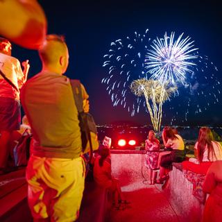 Des gens assistent à des feux d'artifices lors de la fête nationale suisse en 2022 à Nyon. [Keystone - Valentin Flauraud]
