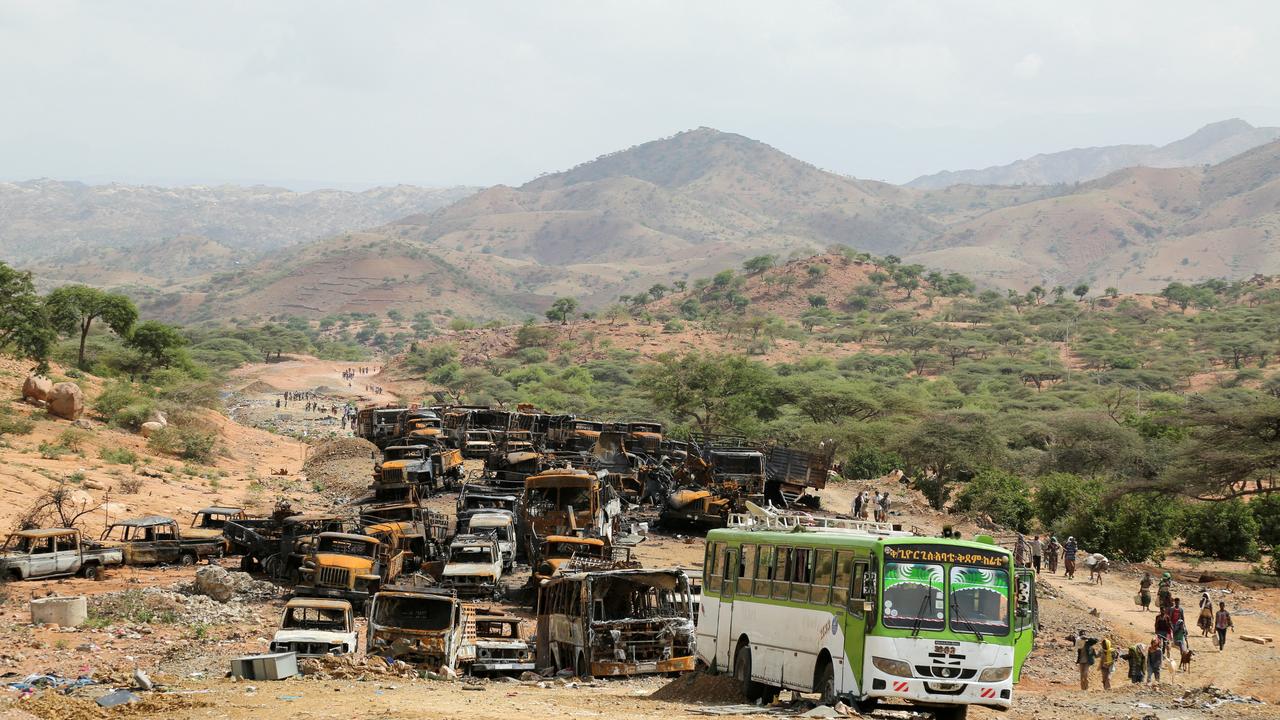 Des villageois retournent à leur villages et passent à côté de véhicule brûlés au Tigré. Image d'illustration [REUTERS - GIULIA PARAVICINI]