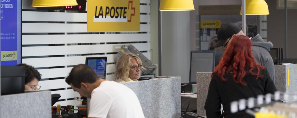 Des clients sont au guichet d'une Poste à Fribourg. [Keystone - Laurent Gillieron]