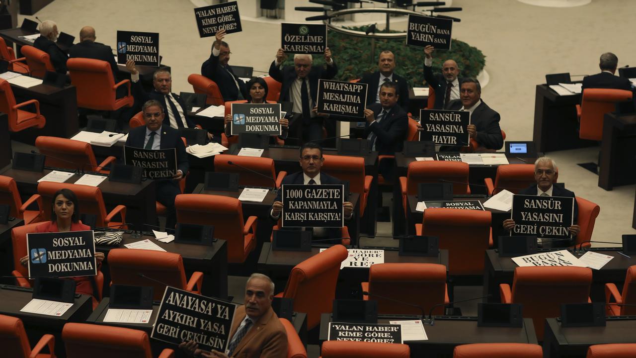 L'opposition, ici des élus du Parti républicain du peuple protesant au Parlement le 11 octobre, a vainement tenté de faire obstacle à ce texte déposé en mai par les députés AKP - le Parti de la justice et du développement du président Recep Tayyip Erdogan. [Keystone - AP Photo/Burhan Ozbilici]