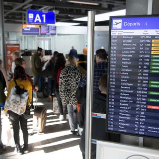 Des passagers dans l'aéroport de Genève Cointrin en février 2020. [Keystone - Laurent Gillieron]