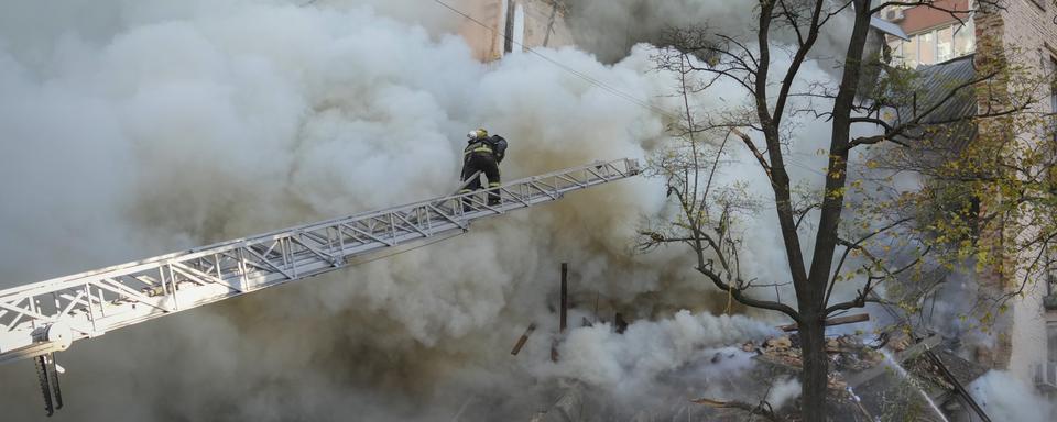 Les pompiers tentent d'éteindre les incendies provoqués par une attaque de drones lundi à Kiev. [Keystone/AP - Efrem Lukatsky]