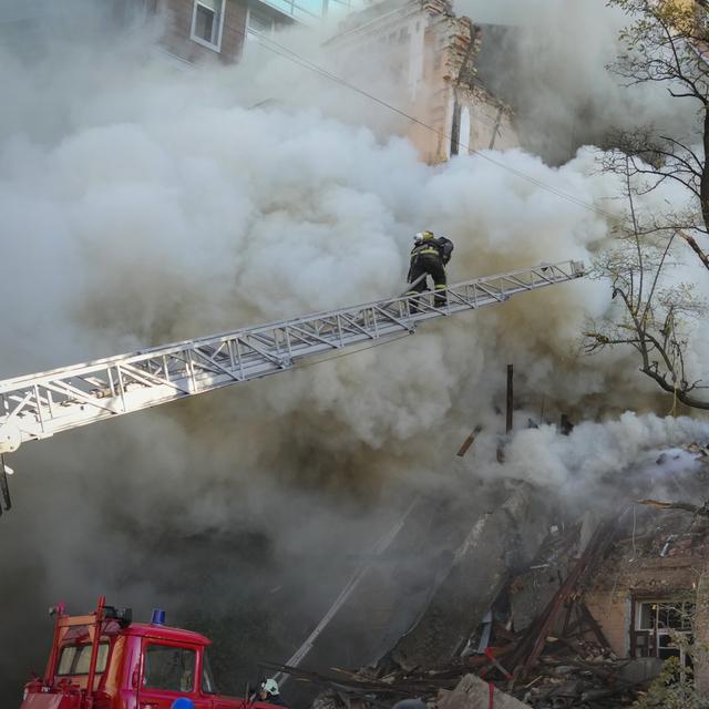 Les pompiers tentent d'éteindre les incendies provoqués par une attaque de drones lundi à Kiev. [Keystone/AP - Efrem Lukatsky]