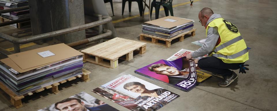 Un employé de France Affichage Plus prépare des affiches pour les élections présidentielles françaises de 2022 au centre d'expédition de Mitry-Mory, près de Paris, France, le 21 mars 2022. [EPA/KEYSTONE - Yoan Valat]