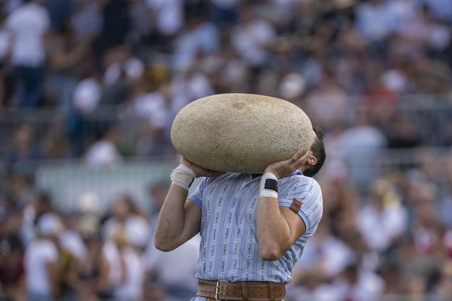 Le lancer de la pierre d'Unspunnen à la Fête fédérale de lutte. [Keystone - Georgios Kefalas]