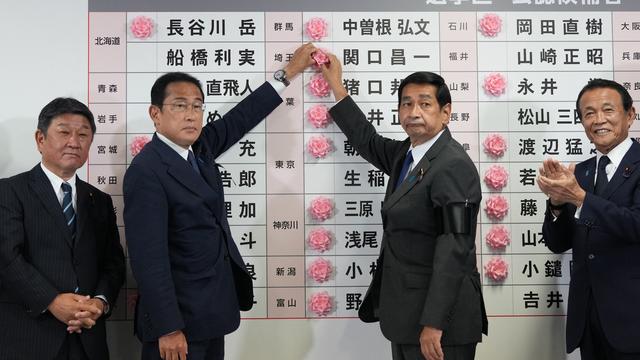 Le premier ministre du Japon Fumio Kishida et le président du Parti libéral-démocrate (PLD), placent une rose sur le nom d'un candidat du PLD, avec les cadres de son parti pour indiquer une victoire aux élections de la chambre haute, à Tokyo, le 10 juillet 2022. [AFP - Toru Hanai / Anadolu Agency]