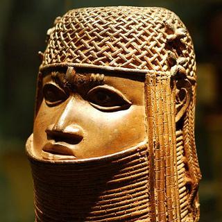 Tête d'Oba (roi), bronze du Bénin exposé au Bristol Museum. En juillet 2022, l'Allemagne et le Nigeria ont signé un accord en vue de la restitution de ce qu'on appelle communément les "bronzes du Bénin". Des centaines de pièces de ce type, pillées lors des colonisations britanniques, sont toujours conservées au British Museum (Londres). [wikimedia - Matt Neale]