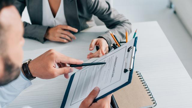 Deux personnes examinent un contrat. [Depositphotos - Vitalikradko]