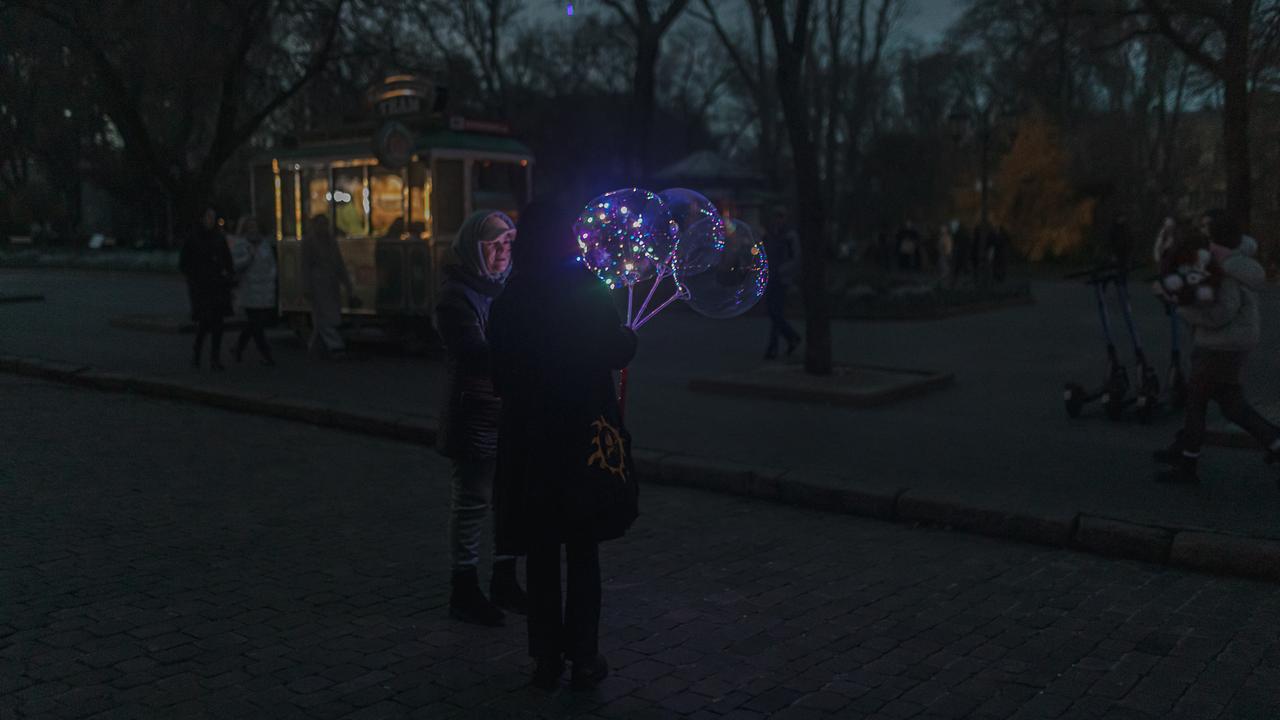 Des habitants discutent au parc dans l'obscurité après une coupure d'énergie due à l'attaque d'un drone kamikaze à Odessa, en Ukraine [AFP]