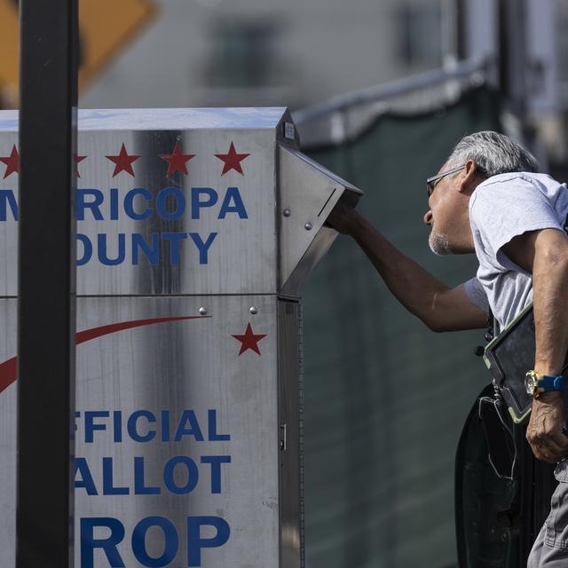 Un électeur dépose son enveloppe de vote dans une boîte officielle dans le comté de Maricopa à Phoenix en Arizona. [Keystone/EPA - Etienne Laurent]