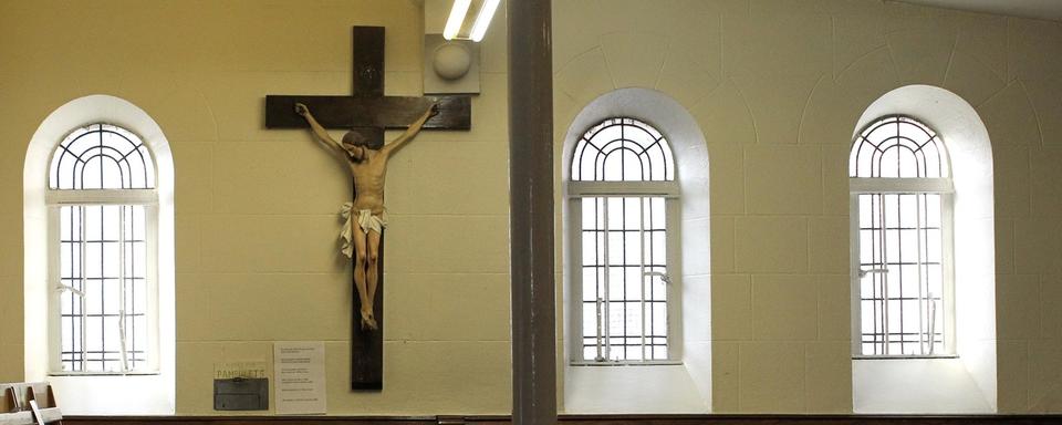 Un homme prie pendant la messe à l'église catholique romaine St Mary à Belfast, en Irlande du Nord. [KEYSTONE - Peter Morrison / AP Photo]