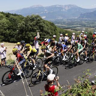 Des spectateurs regardent le peloton en action lors de la 13e étape du Tour de France 2022 sur 192,6 km entre Le Bourg d'Oisans et Saint-Etienne, France, 15 juillet 2022. [EPA/KEYSTONE - Yoan Valat]