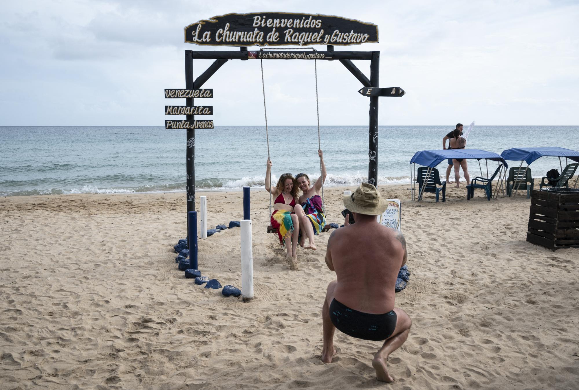 Fin novembre, des touristes russes posent au bord de la mer sur l'île Margarita, au Vénézuela. [AFP - Yuri Cortez]