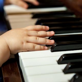 Mains de bébé sur un piano. [Depositphotos - alexandco]