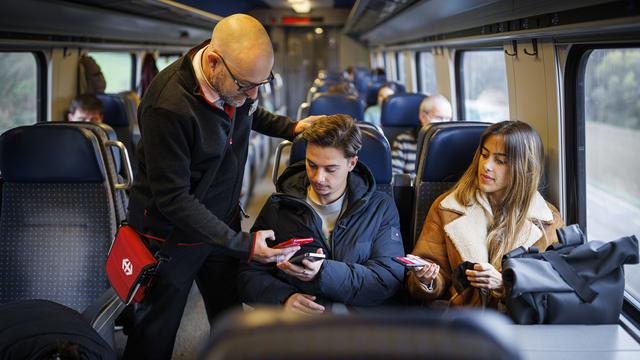 Un contrôleur et des passagers dans un train CFF, sans masques, le jour de la levée des dernières mesures sanitaires, le 1er avril 2022. [Keystone - Valentin Flauraud]