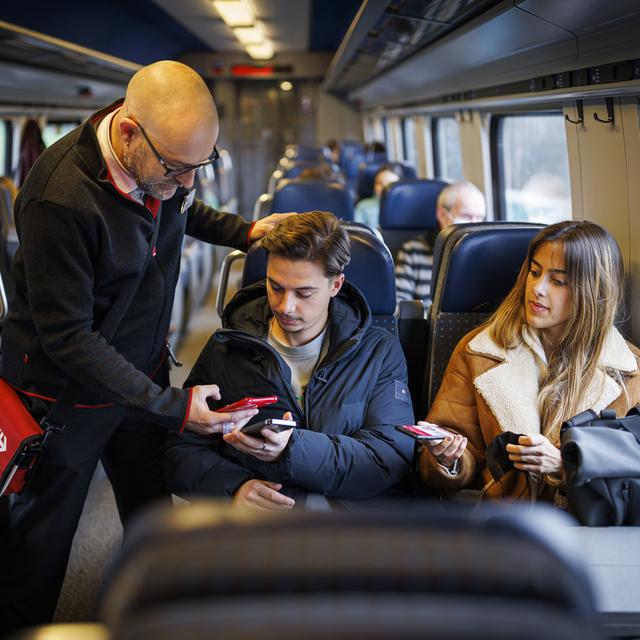 Un contrôleur et des passagers dans un train CFF, sans masques, le jour de la levée des dernières mesures sanitaires, le 1er avril 2022. [Keystone - Valentin Flauraud]