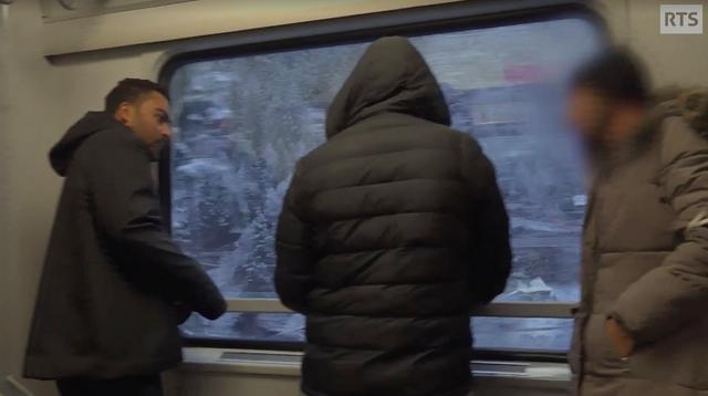 Les trois jeunes migrants dans le couloir du train. [RTS - Mise au point]