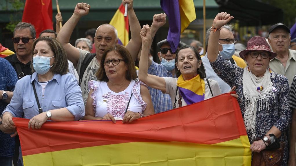 Des manifestants brandissent un drapeau républicain lors d'une manifestation anti-monarchie à Madrid, le 22 mai 2022, qui coïncide avec le retour en Espagne de l'ancien roi Juan Carlos Ier. [AFP - Pierre-Philippe Marcou]