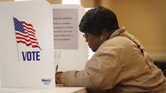 Une femme vote lors des élections des élections américaines de mi-mandat en Ohio en 2018. [Keystone - EPA/DAVID MAXWELL]