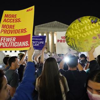 Une foule de personnes se rassemble devant la Cour suprême, dans la nuit du lundi 2 mai 2022 à Washington. [AP Photo/KEYSTONE - Alex Brandon]