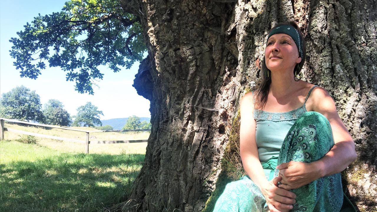 Florence Reber Mittenpergher au pied du plus vieux chêne d’Europe à Châtillon (JU). Photo prise pour son passage dans Les bonnes ondes le 13.07.2022. [RTS - Antoine Droux]