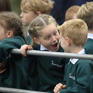 Des enfants qui discutent pendant la visite du roi Charles II et la reine Camilla. [Keystone/EPA - Mark Marlow]