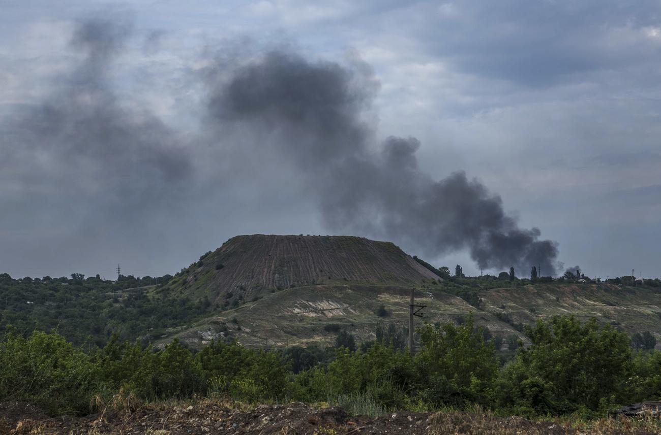 La fumée des bombardements s'élève près d'une usine de déchets miniers à Lyssytchansk,  le 18 juin 2022. [Keystone - Oleksandr Ratushniak]
