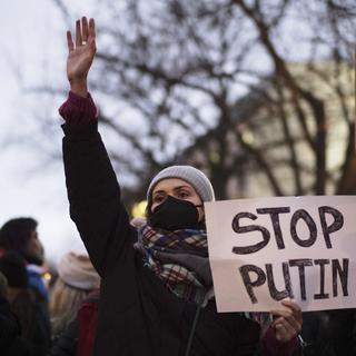 Une femme montre une affiche de soutien à l'Ukraine lors d'une manifestation dans la rue près de l'ambassade de Russie pour protester contre l'escalade de la tension entre la Russie et l'Ukraine à Berlin, en Allemagne, mardi 22 février 2022. [AP Photo/KEYSTONE - Markus Schreiber]