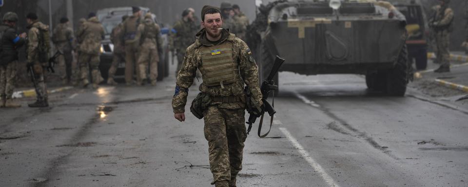 Un soldat de l'armée ukrainienne marche après une opération de ratissage militaire visant à rechercher d'éventuels restes de troupes russes après leur retrait des villages dans la banlieue de Kiev, en Ukraine, vendredi 1er avril 2022. [AP Photo/Keystone - Rodrigo Abd]