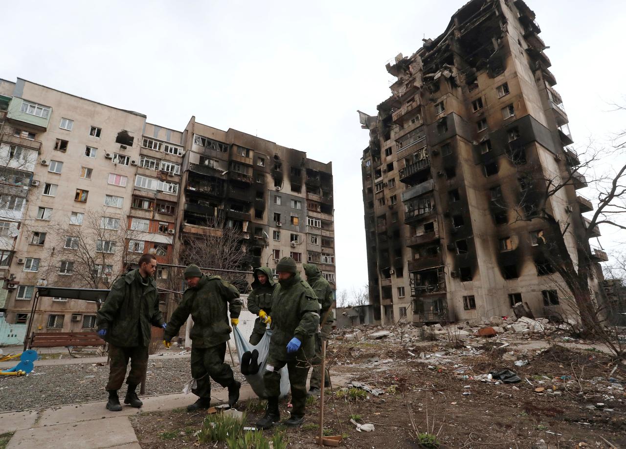 Des soldats prorusses évacuent un corps à Marioupol. [Reuters - Alexandre Ermochenko]