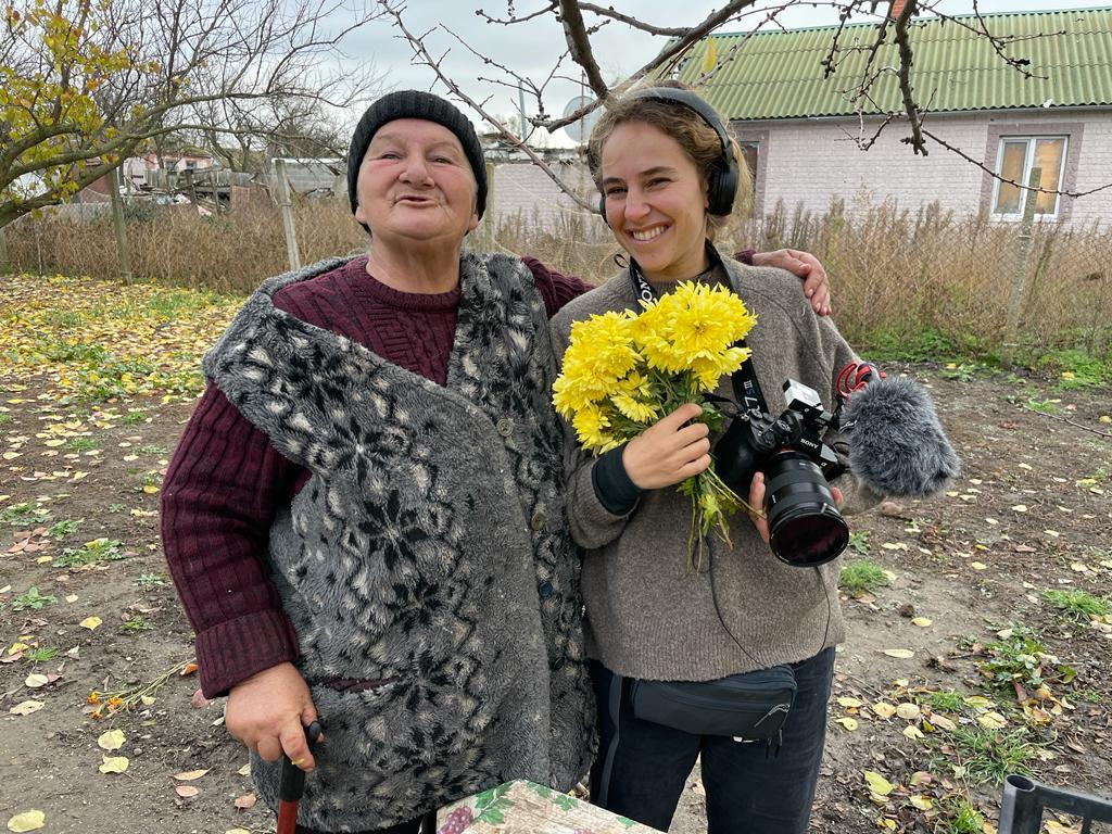 Nadezdha, une habitante d'Oleksandrivka, 40 km Kherson, offre des fleurs à notre JRI Sharon Aronowicz. [RTS - Tristan Dessert]