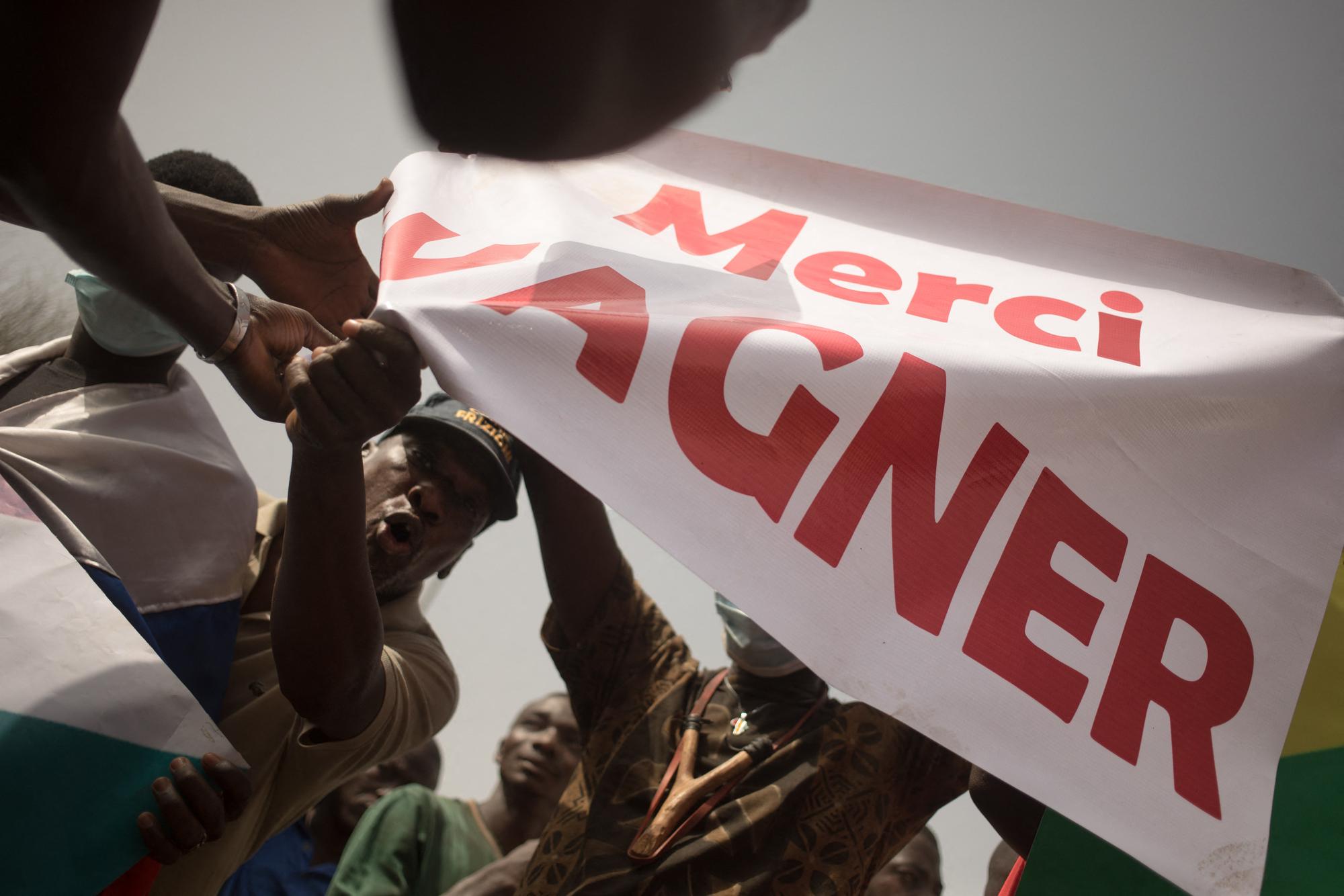 Des manifestants brandissent une affiche "Merci Wagner" lors d'un rassemblement organisé par le mouvement Yerewolo pour célébrer l'annonce du retrait français, le 19 février 2022. [AFP - Florent Vergnès]