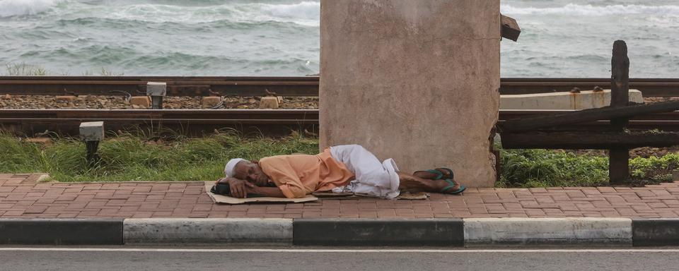 Une personne dort dans la rue au Sri Lanka, le 15 juin 2022. [Keystone/EPA - Chamila Karunarathne]