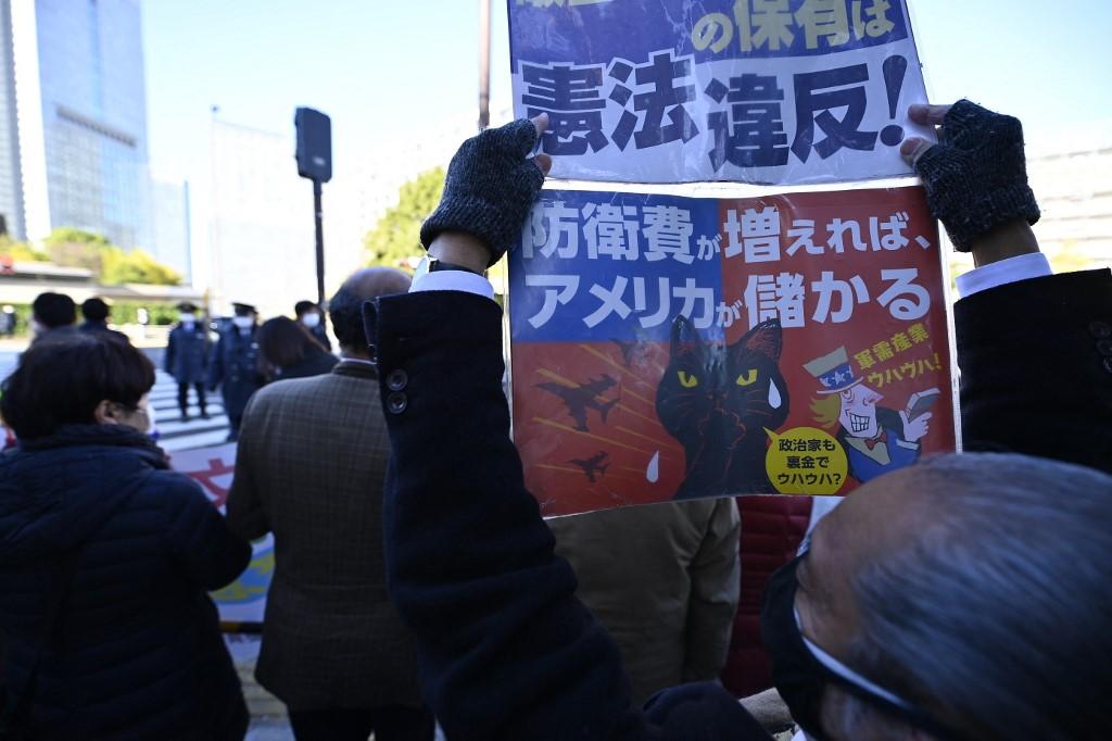 Des manifestants ont dénoncé le jour même une violation de l'article 9 de la Constitution nipponne, où il est écrit que le peuple japonais renonce à la guerre et à l'usage de la force, devant le bureau du Premier ministre Fumio Kishida à Tokyo. [AFP - David Mareuil / Anadolu Agency]