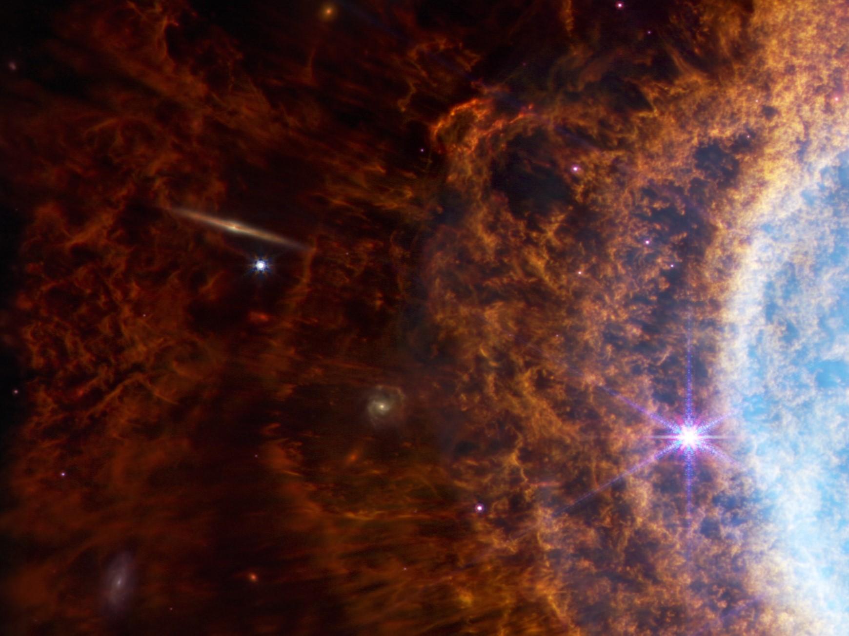 Une surprise de taille dans l'anneau austral NGC 3132: un trait jaune... une galaxie se découpe dans la poussière, en haut à gauche de la photo. [NASA, ESA, CSA, and STScI]