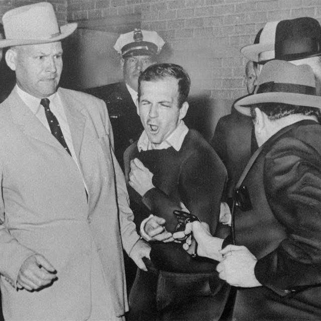 Lee Harvey Oswald (au centre), l'assassin présumé du président John F. Kennedy, est abattu le 24 novembre 1963 dans un couloir du quartier général de la police de Dallas par Jack Ruby (de dos, à droite), propriétaire d'une boîte de nuit. Avant son procès, Ruby a déclaré: "On ne saura jamais la vérité, ni pourquoi j'ai agi. Les personnes qui ont tant à gagner et un motif puissant pour me mettre où je suis ne laisseront jamais éclater la vérité." [AP Photo-Dallas Times-Herald - Bob Jackson]