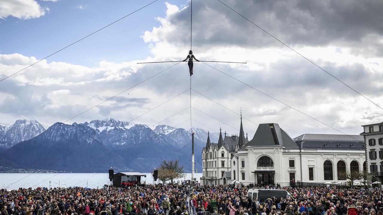 La funambule de la compagnie Basinga, Tatiana-Mosio Bongonga, traverse la place du Marché de Vevey sur un câble de 180 mètres de long lors du spectacle "Ligne Ouverte". [KEYSTONE - Gabriel Monnet]