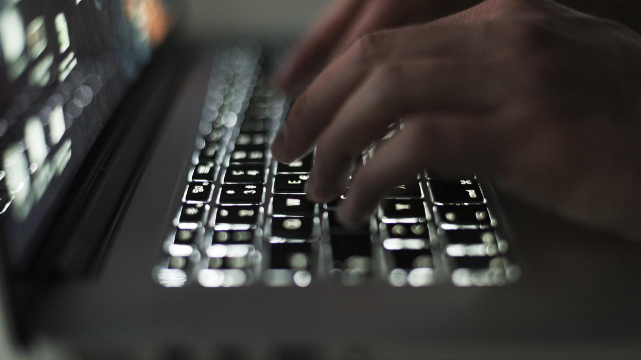 Un individu utilise un ordinateur portable avec un clavier lumineux, à Zurich, en Suisse, le 5 mars 2019. [KEYSTONE - Christian Beutler]