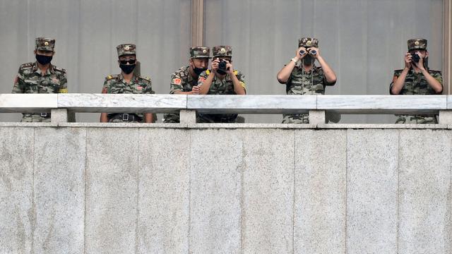 Des soldats nord-coréens surveillent la frontière alors que le ministre sud-coréen de l'Unification, Lee In-young visite la zone de sécurité commune (JSA) sur la zone démilitarisée (DMZ), le 16 septembre 2020. Cette zone minée (on estime le nombre de mines à 1 million) est surveillée par 700'000 soldats nord-coréens et 410'000 soldats sud-coréens aidés par la 2e division d’infanterie des États-Unis, avec qui la Corée du Sud a signé un pacte de sécurité. Il s'agit d'un des rares vestiges de la guerre froide, équivalent à l’ancien rideau de fer. [KOREA POOL/Keystone - Park Tae-Hyun]