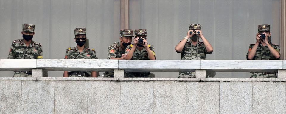 Des soldats nord-coréens surveillent la frontière alors que le ministre sud-coréen de l'Unification, Lee In-young visite la zone de sécurité commune (JSA) sur la zone démilitarisée (DMZ), le 16 septembre 2020. Cette zone minée (on estime le nombre de mines à 1 million) est surveillée par 700'000 soldats nord-coréens et 410'000 soldats sud-coréens aidés par la 2e division d’infanterie des États-Unis, avec qui la Corée du Sud a signé un pacte de sécurité. Il s'agit d'un des rares vestiges de la guerre froide, équivalent à l’ancien rideau de fer. [KOREA POOL/Keystone - Park Tae-Hyun]